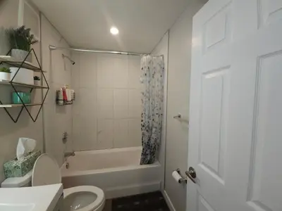 a bathroom with a white toilet and a shower at Cozy 2 Bedroom Suite, Queen Beds, Near the Airport in Edmonton