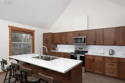 a kitchen with wooden cabinets and a white counter top at The Evergreen Cabin in Valemount