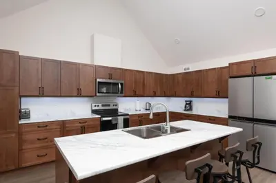 a kitchen with wooden cabinets and a white counter top at The Evergreen Cabin in Valemount