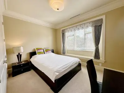 a bedroom with a large bed and a window at Campus Haven in Vancouver