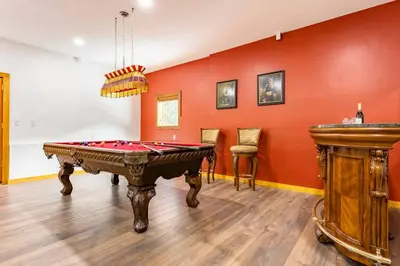 a room with a pool table and a red wall at Gem by Manning Park: Luxury Loghouse “Ravenloft” in Sunshine Valley