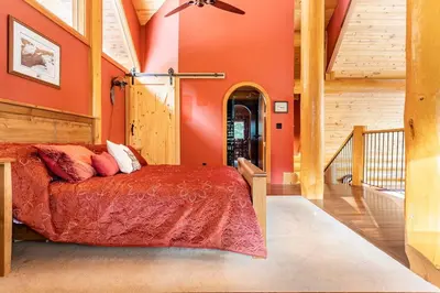 a bedroom with orange walls and a bed in a room at Gem by Manning Park: Luxury Loghouse “Ravenloft” in Sunshine Valley